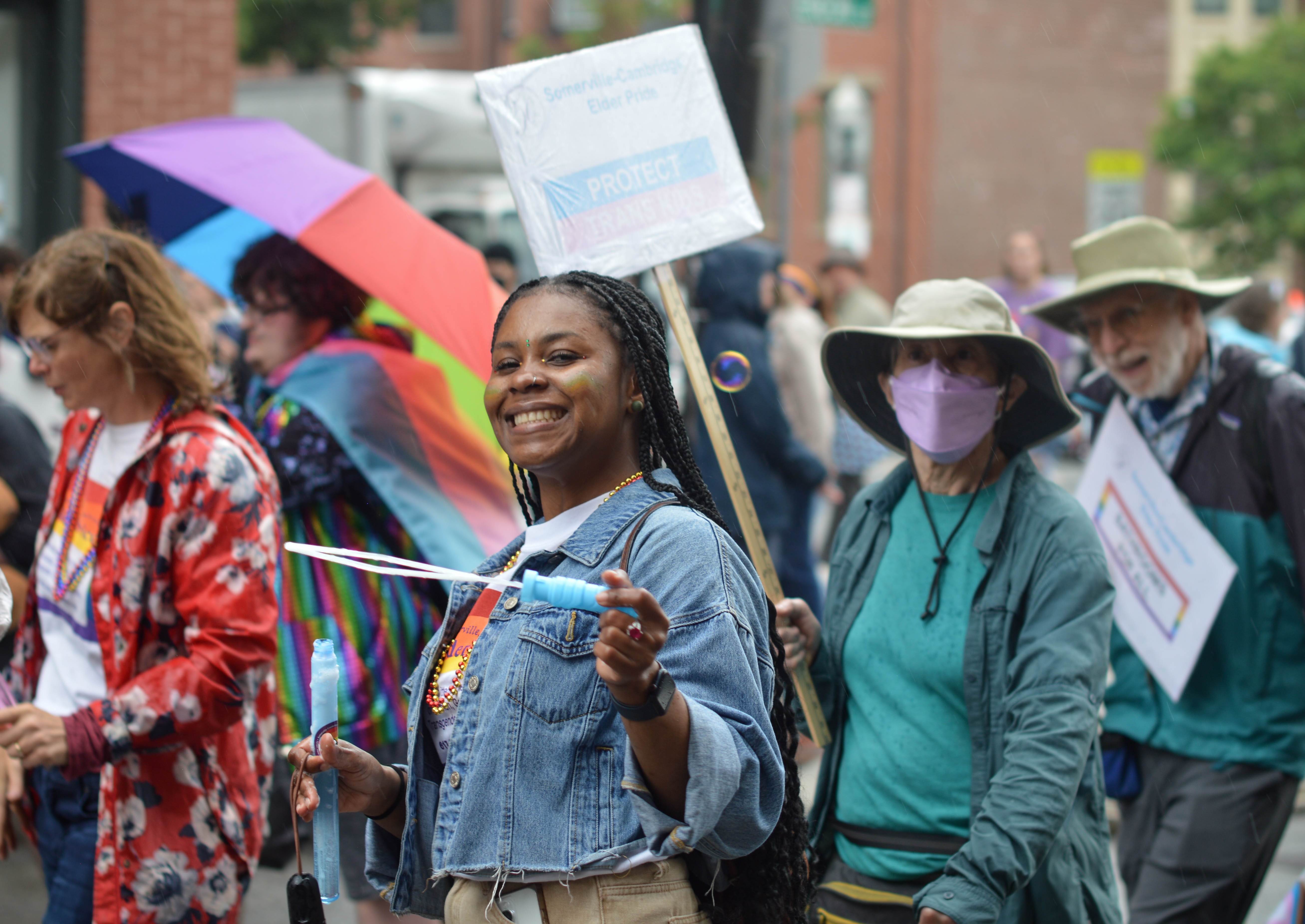 a woman in a pride parade blows a bubble