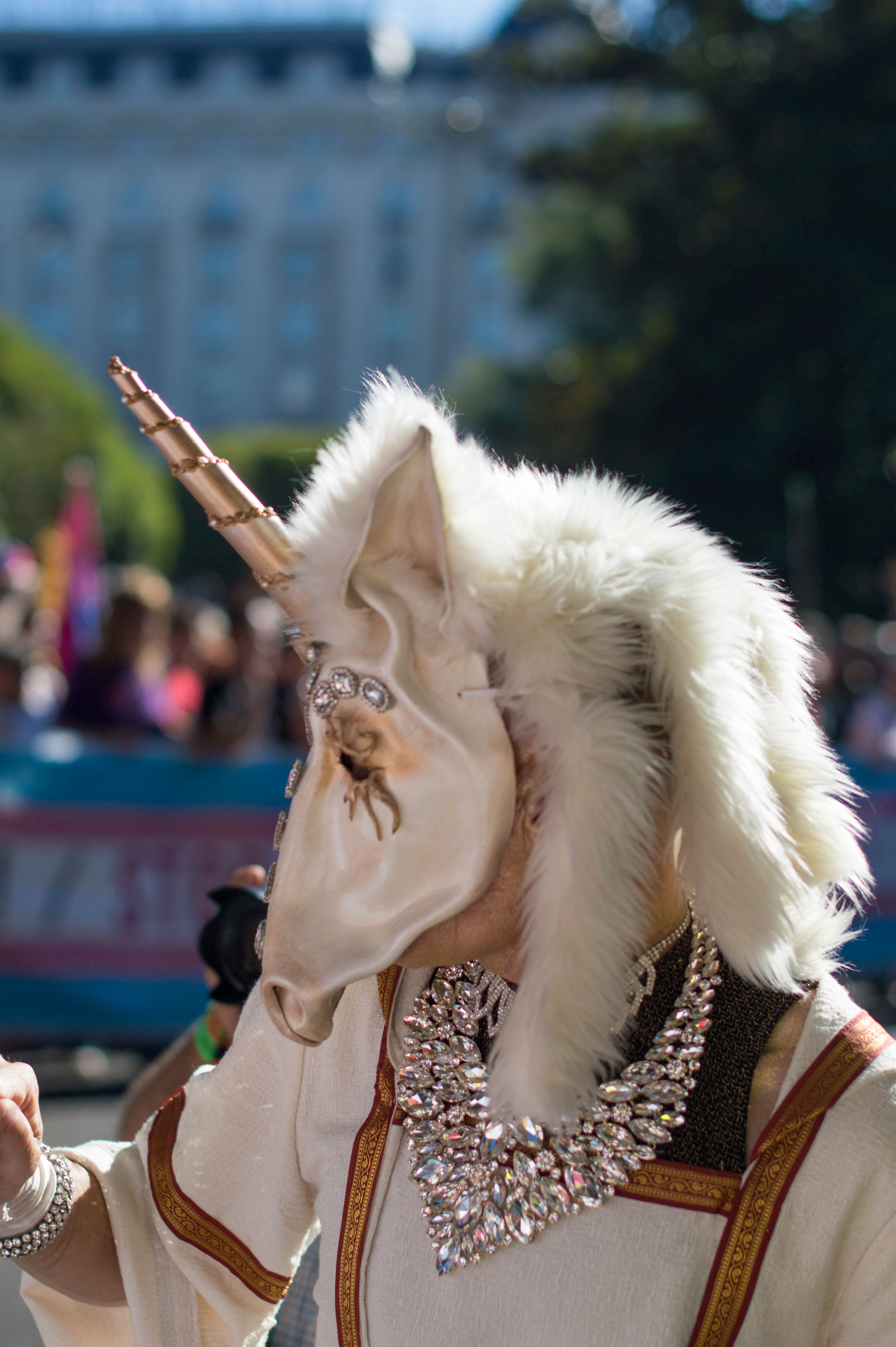 someone in an artistic unicorn mask at a pride parade