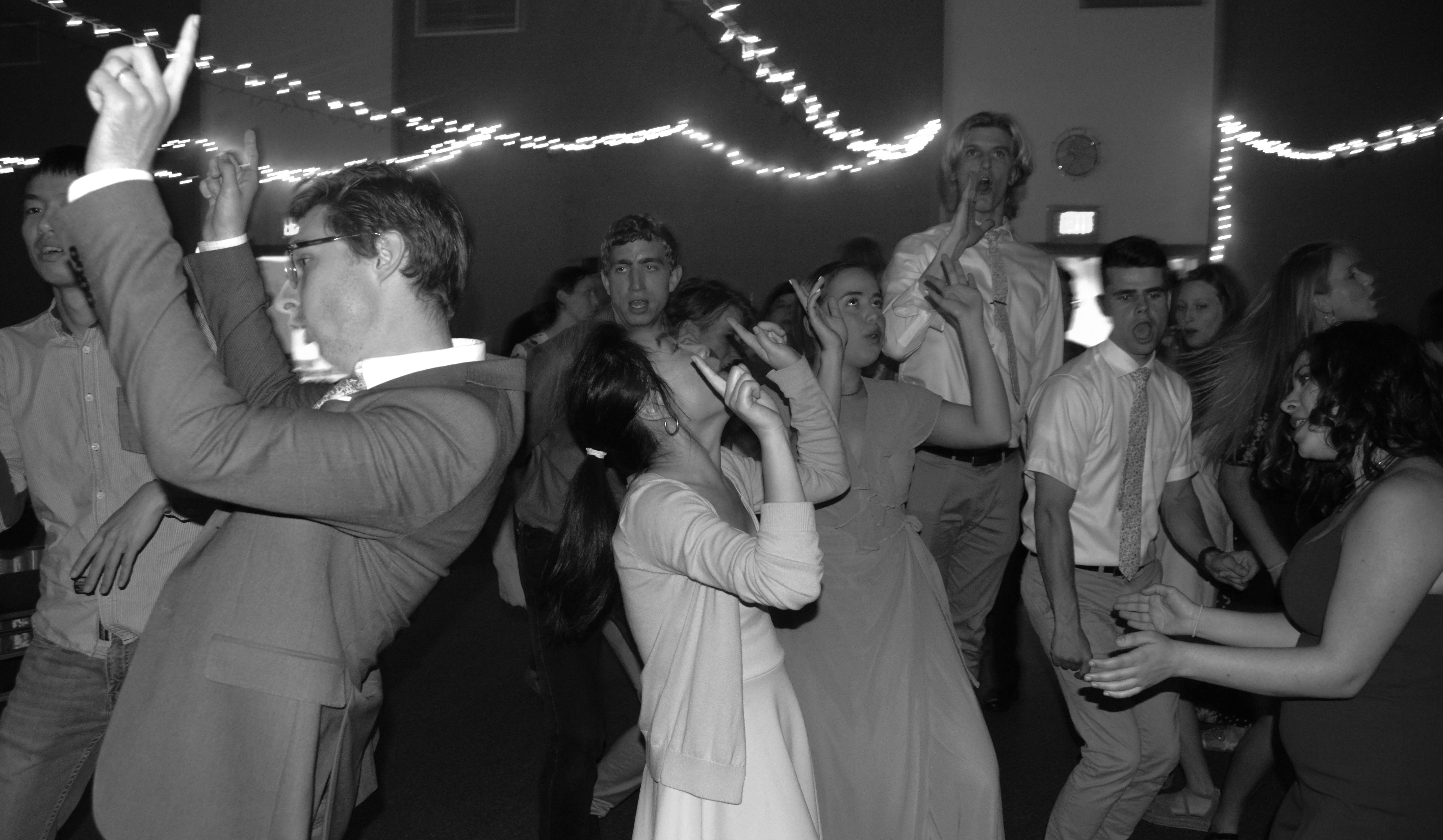 a black and white photo of people dancing at a wedding reception