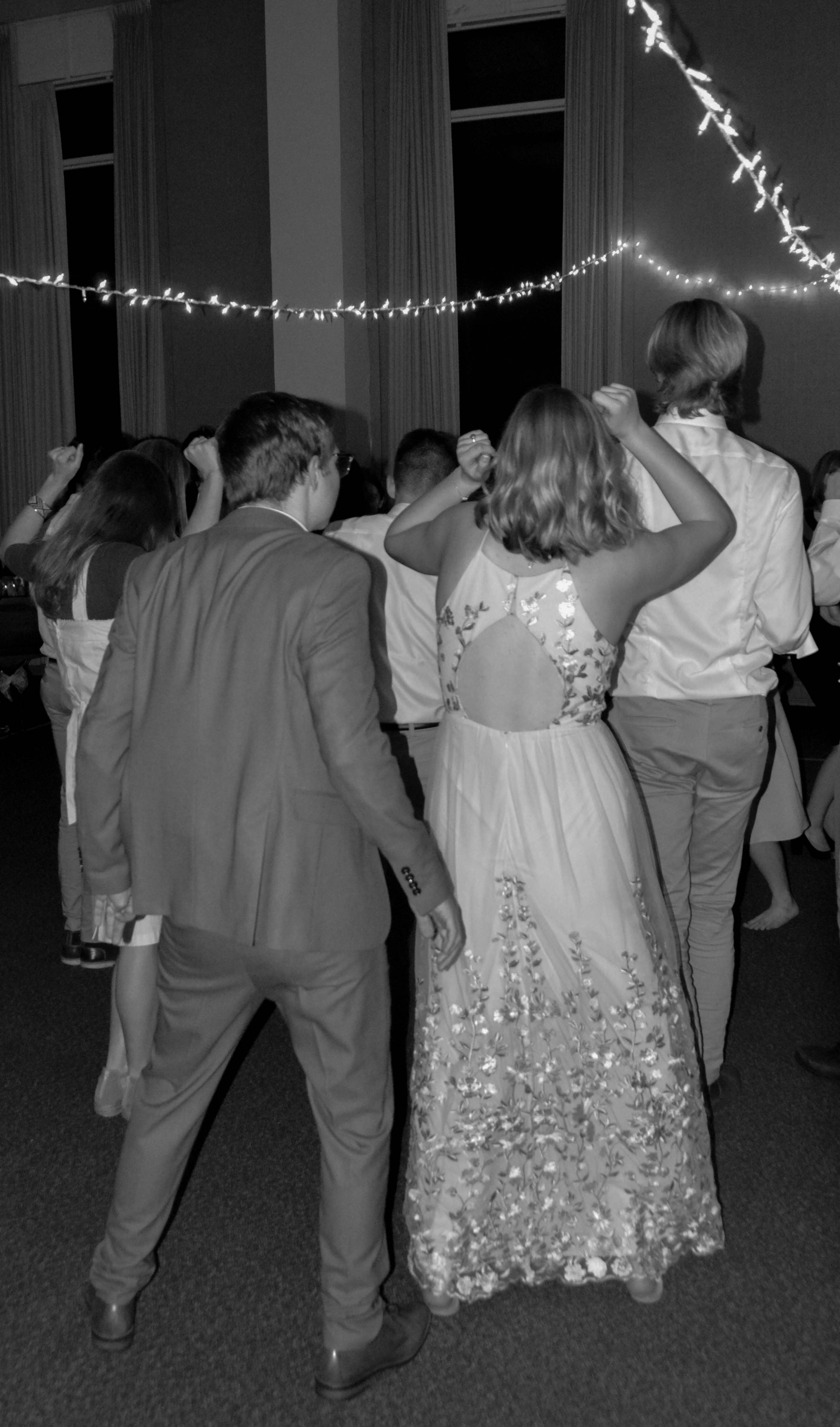 a black and white photo of people dancing at a wedding reception