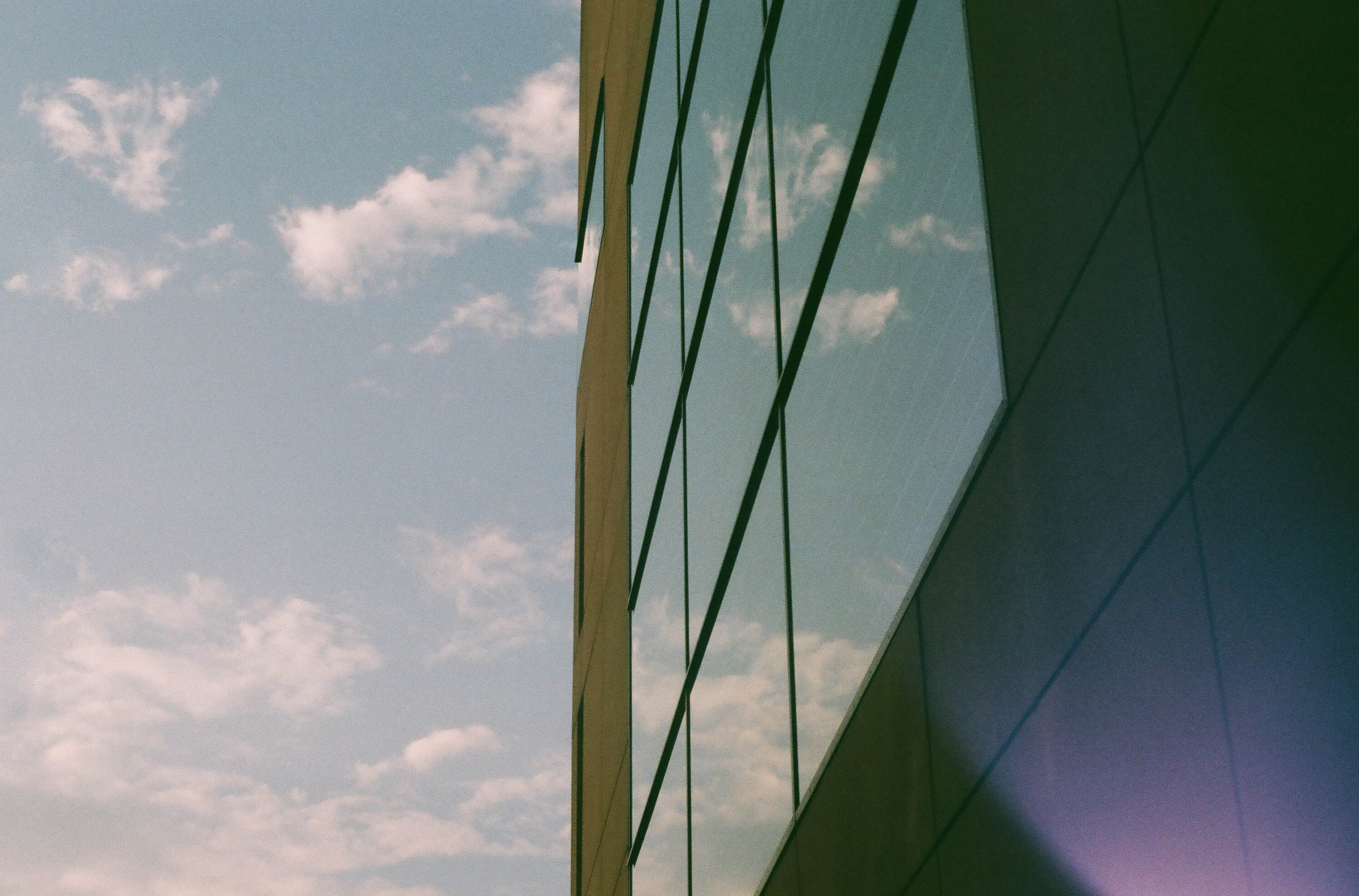 building windows reflect clouds in a blue sky