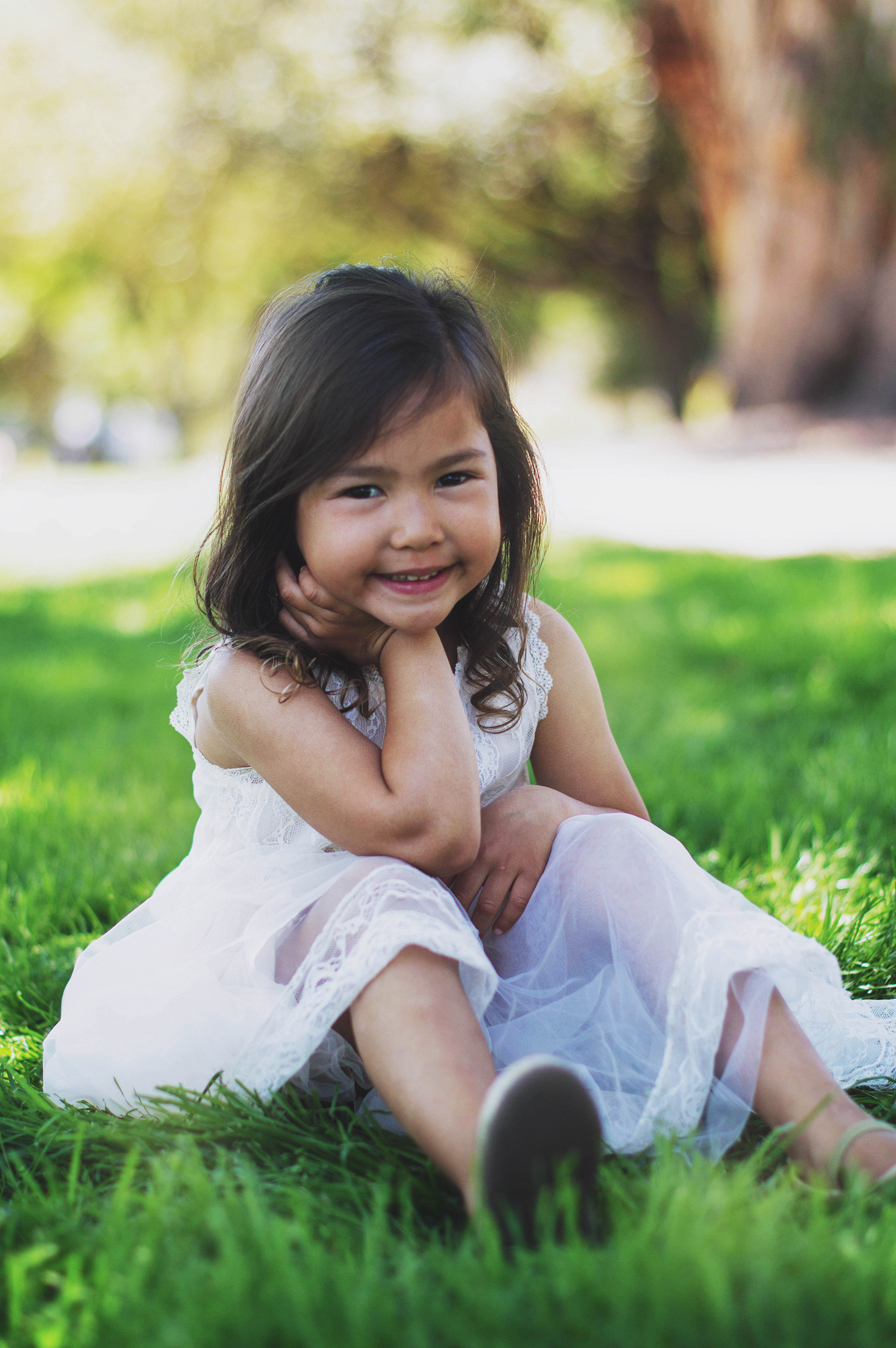 a little girl sitting in the grass