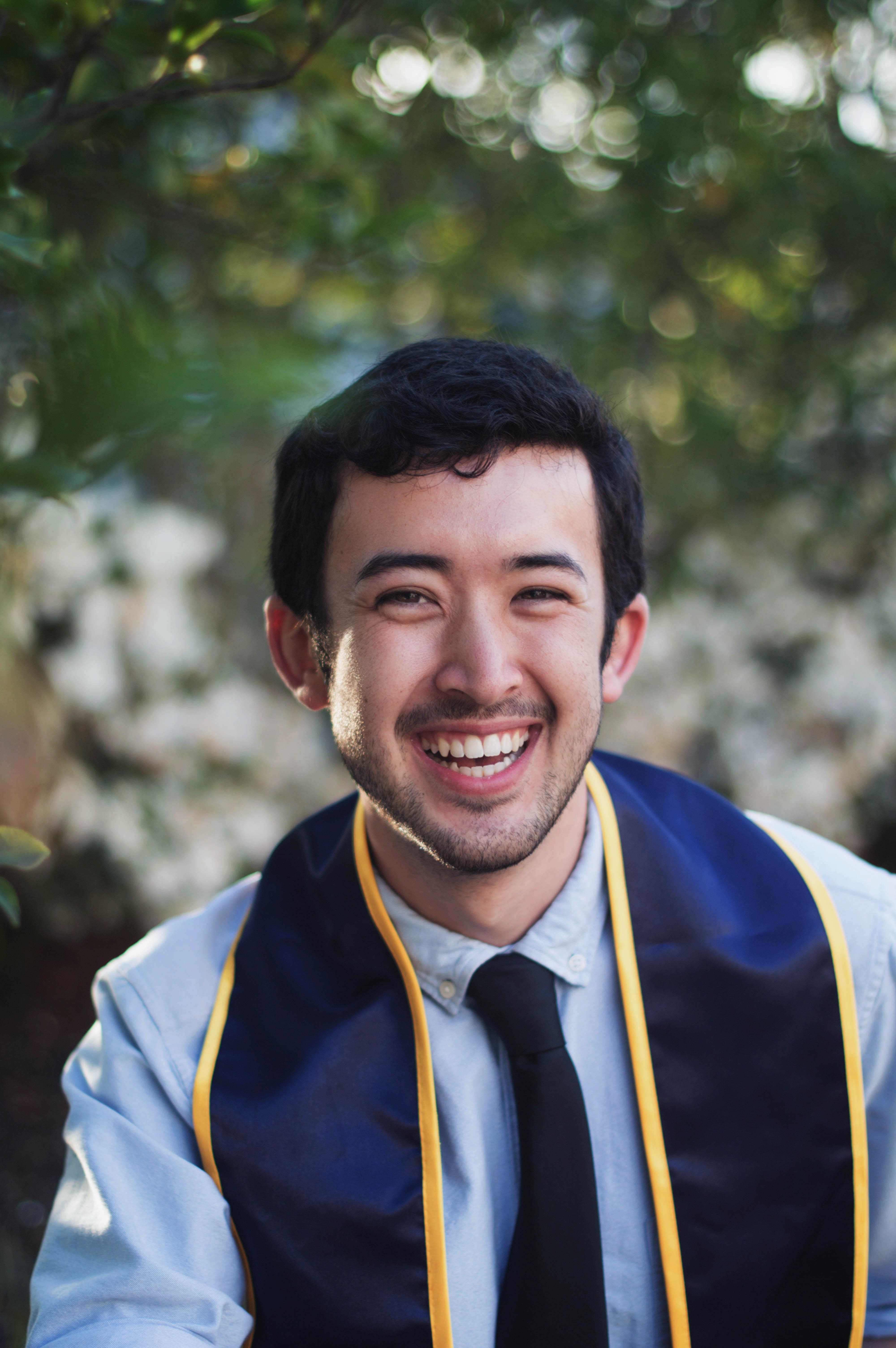 a young man's professional headshot with graduation stole