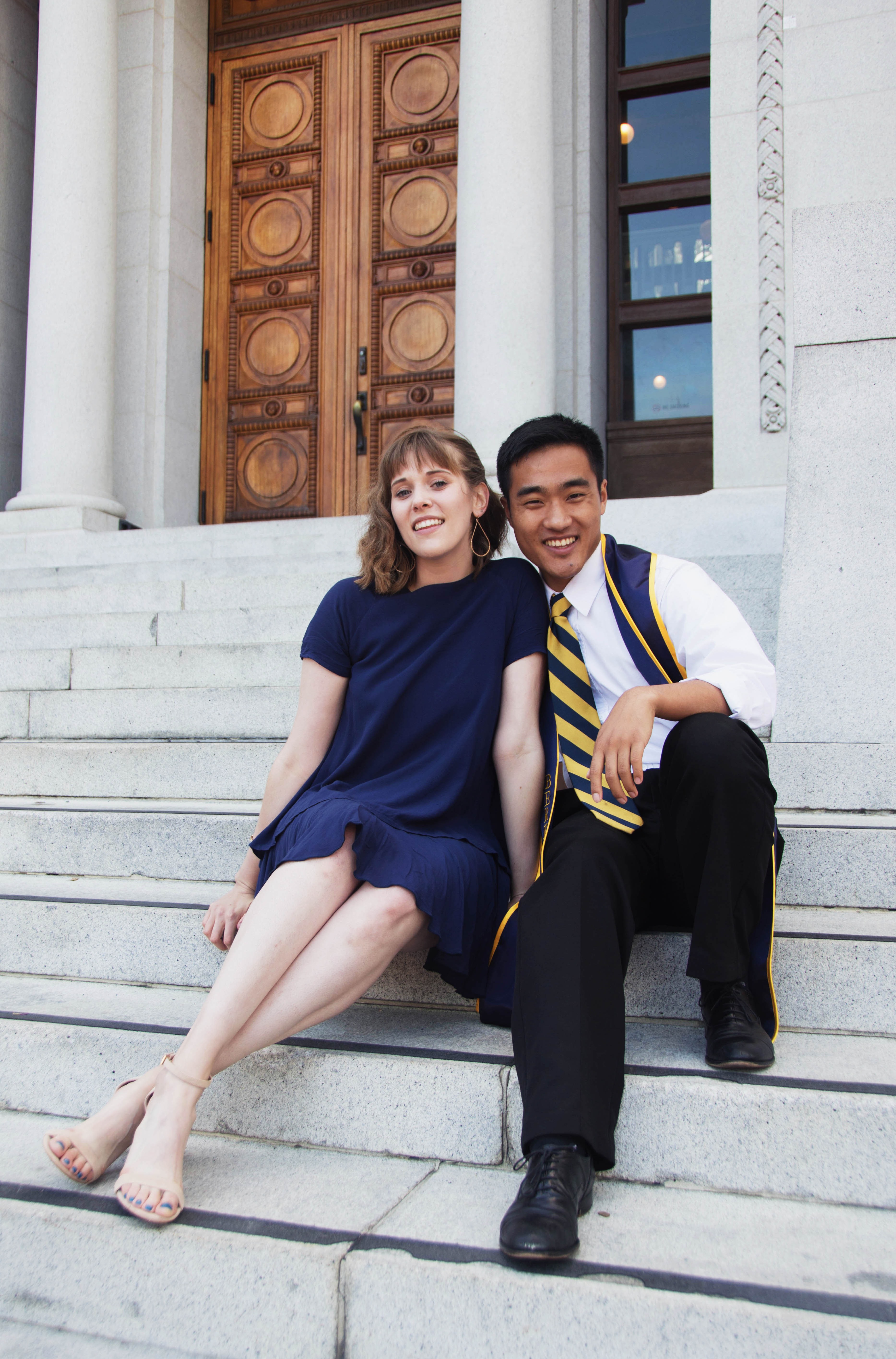 a couple sits on the steps of a marble building