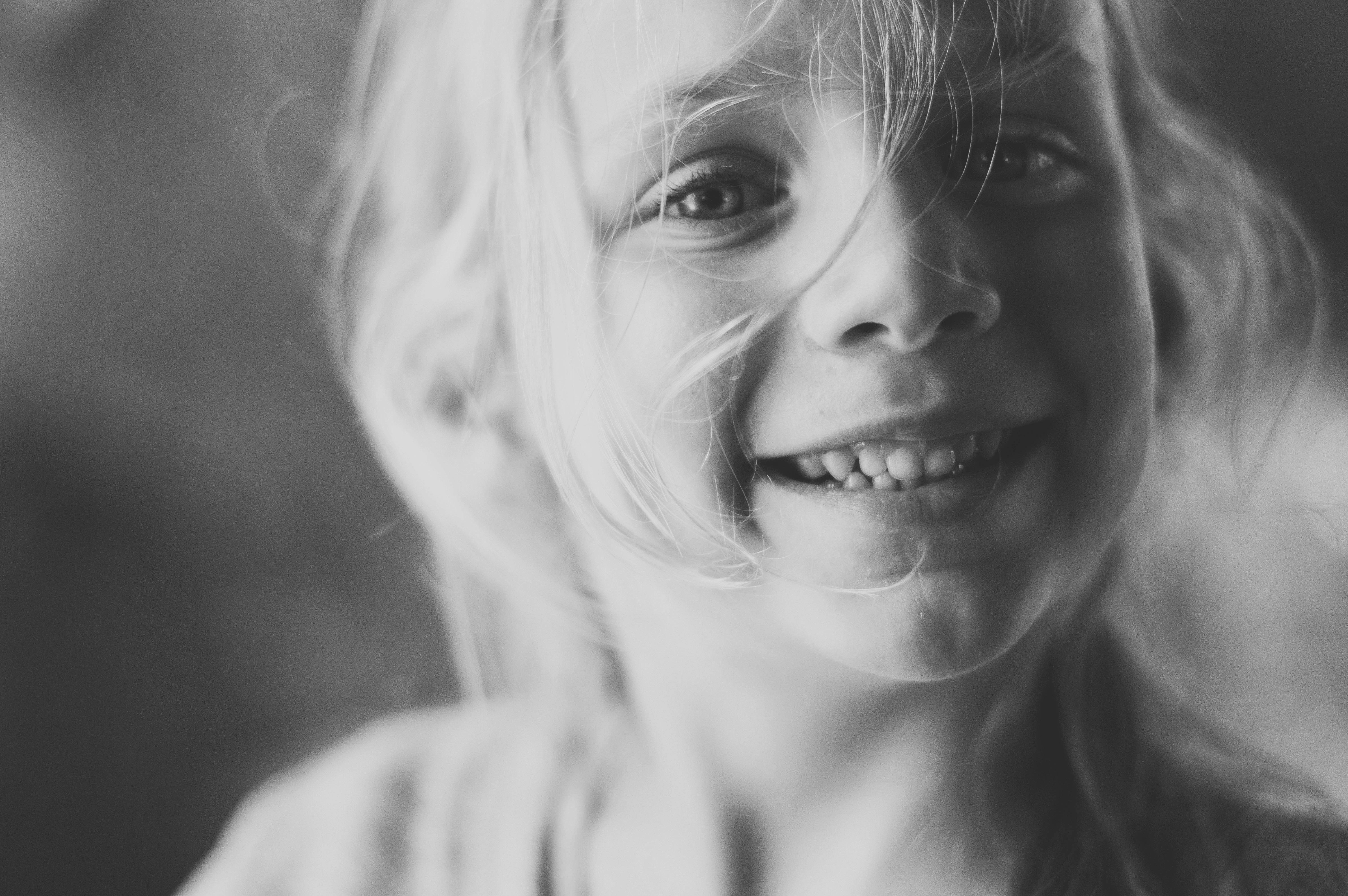 a black and white close up photo of a young child