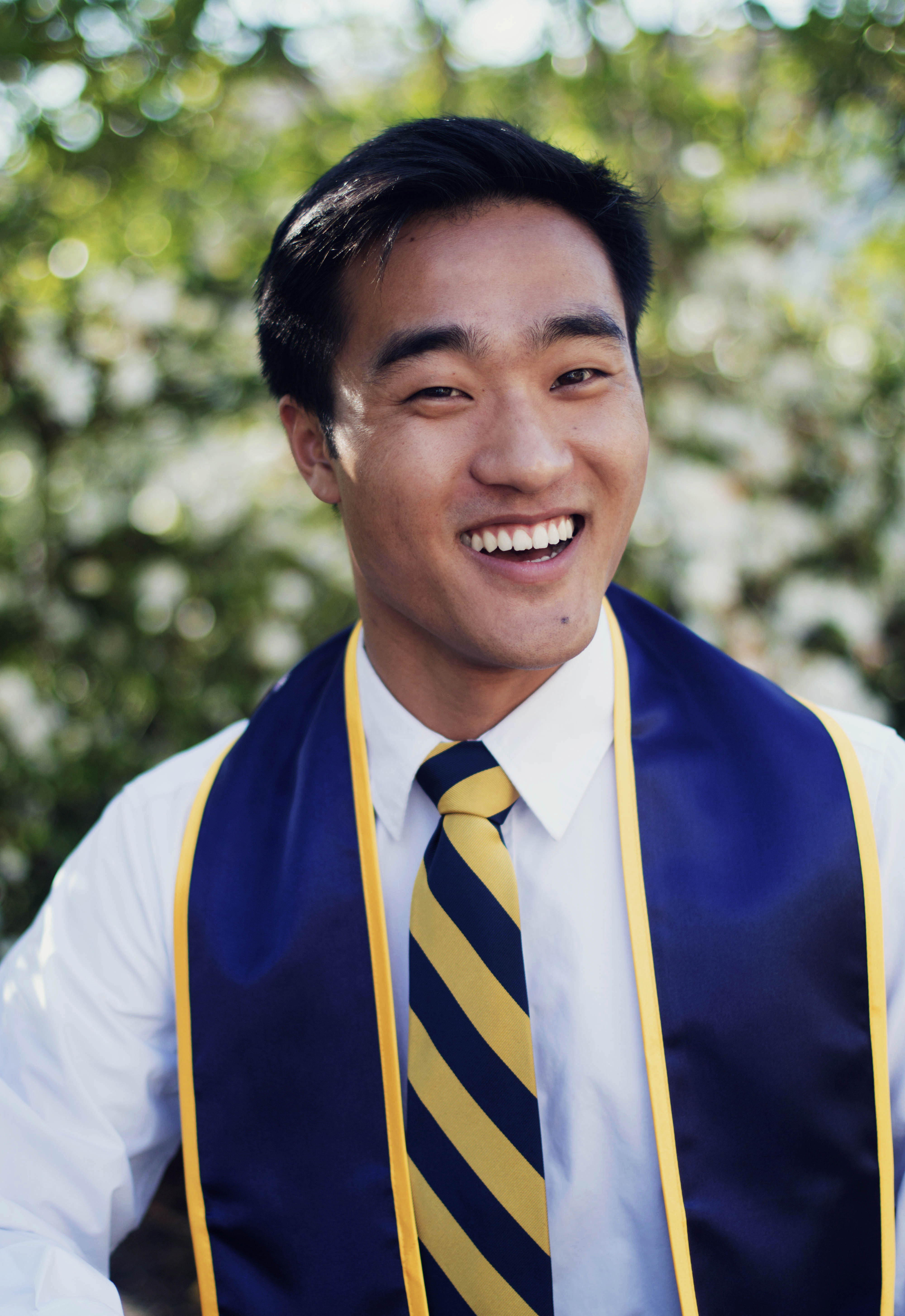 a young man's professional headshot with graduation stole