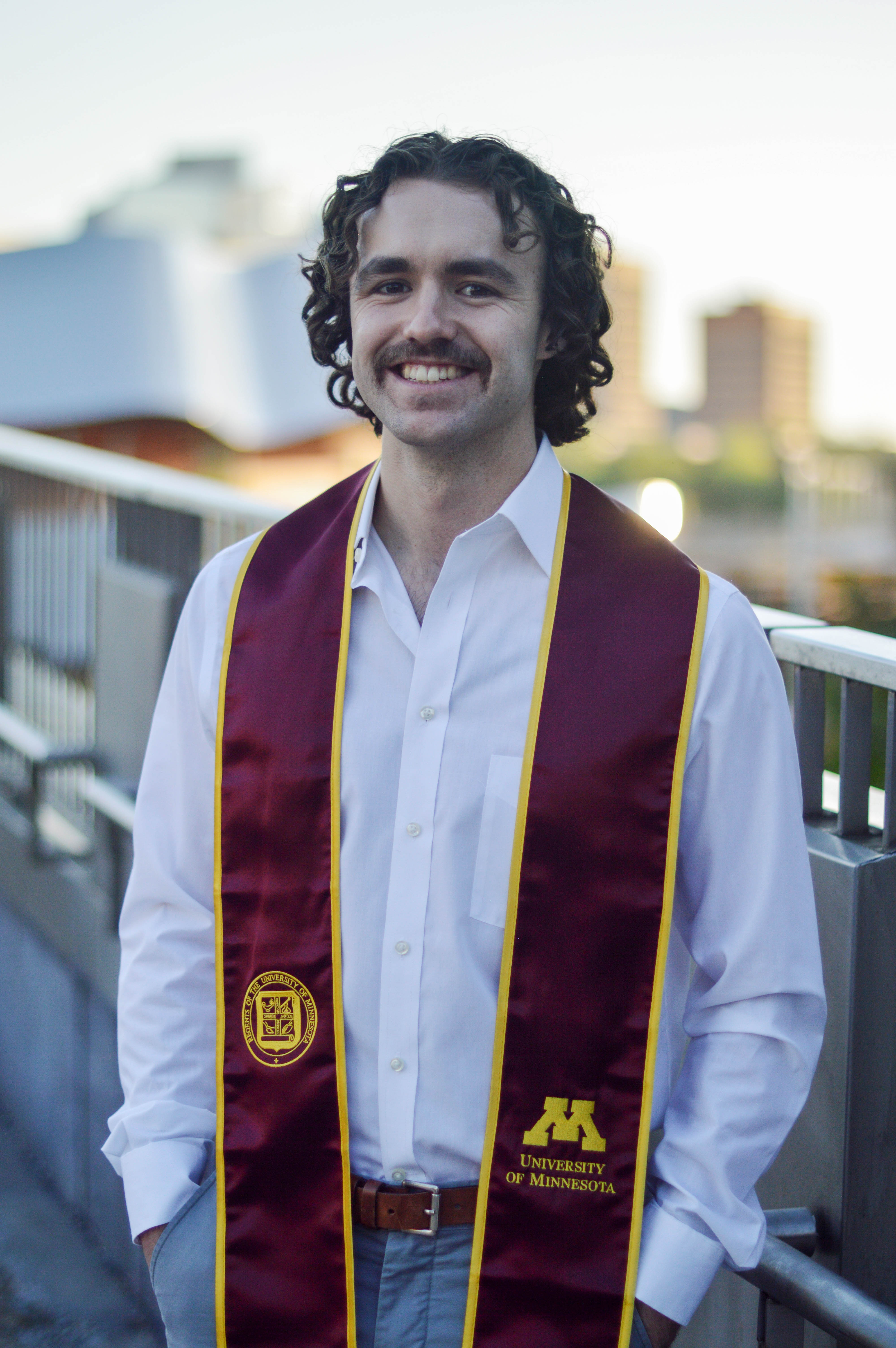 a young man's professional headshot with graduation stole